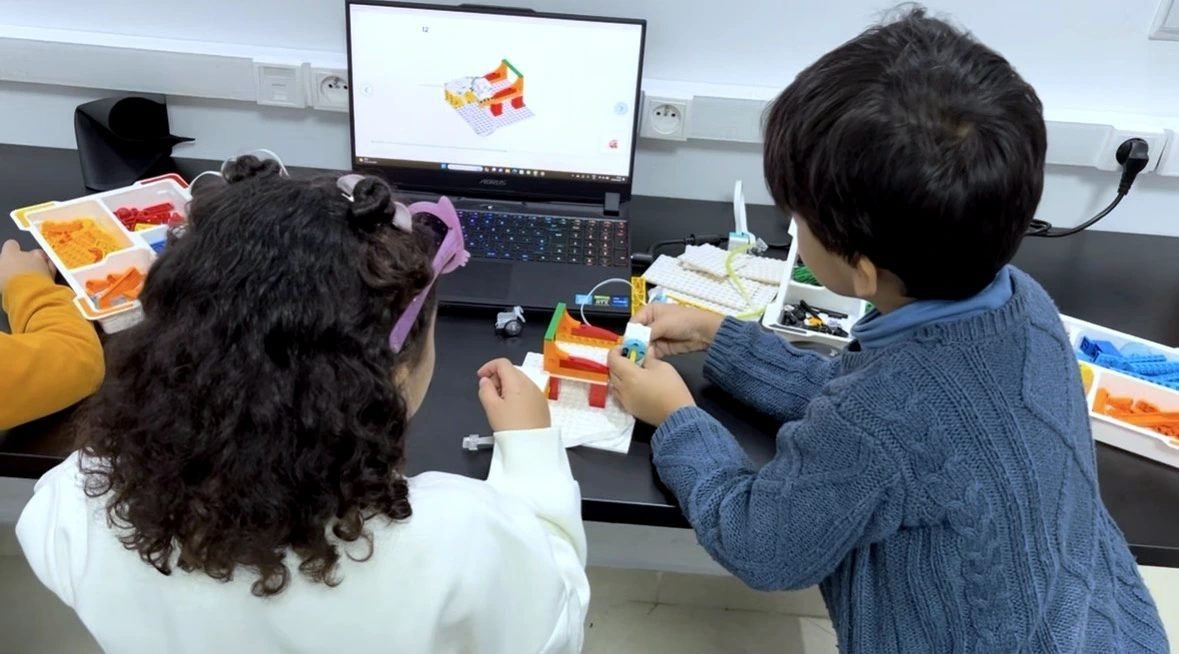 Enfants construisant un robot au stage